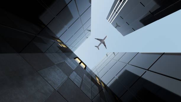istock Plane flying over generic modern glass and concrete office buildings 966689560