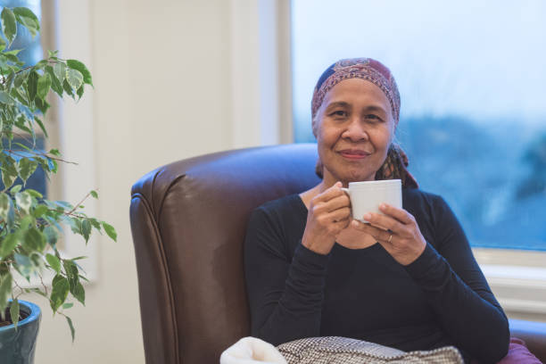 istock Senior woman with cancer sits by her window drinking tea 966689724