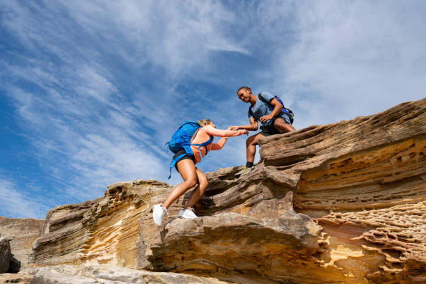 istock Man giving a hand to a woman while hiking 966705946