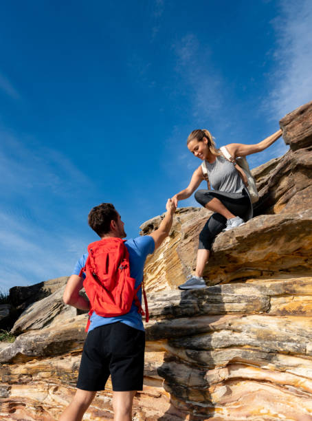 istock Man giving a hand to a woman while hiking 966706000