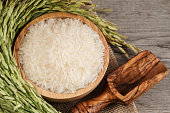 Thai Jasmine white and black rice in wooden bowl with unmilled rice and wooden scoop on wooden background