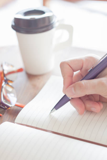 istock Cropped Image Of Woman Writing On Book 966729012