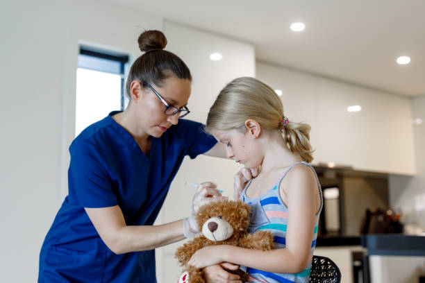Home Call Nurse Giving Child An Injection At Home Home Call Nurse Giving Child An Injection in Australian House injecting flu virus vaccination child stock pictures, royalty-free photos & images