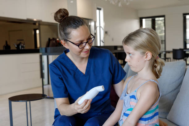 istock Nurse Taking Child's Temperature With Thermometer At Home 966738836