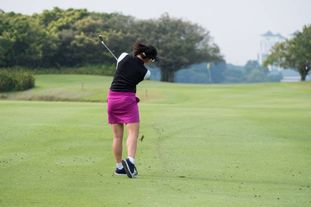 istock Woman golfer hits a great approach shot from the fairway 966739042