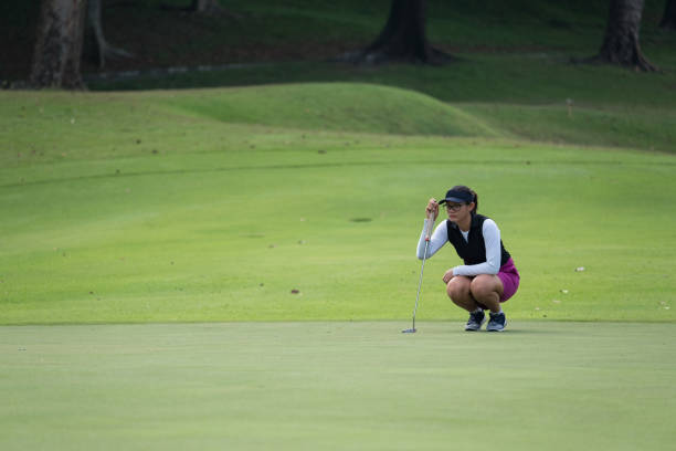 여성 골퍼 그녀의 긴 퍼 팅 라인 - golf putting determination focus 뉴스 사진 이미지