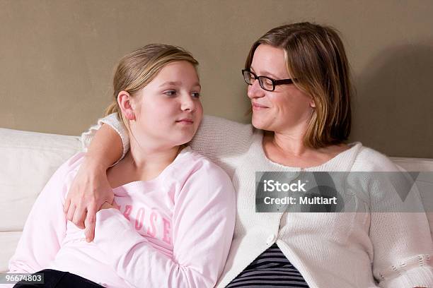 Mother Draping Arm Over Daughter In A White Couch Stock Photo - Download Image Now - Parent, Teenager, Discussion