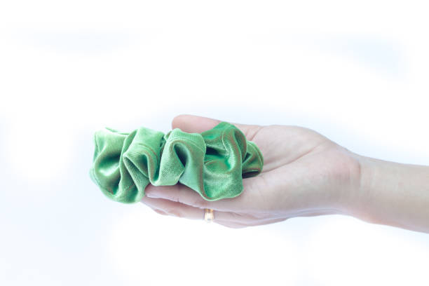 istock Cropped Hand Holding Green Fabric Against White Background 966762120