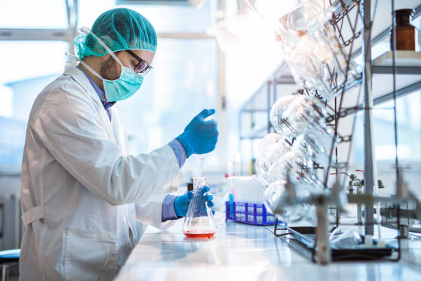 mâle biotechnologue essais de nouvelles substances chimiques en laboratoire. - drug discovery photos et images de collection