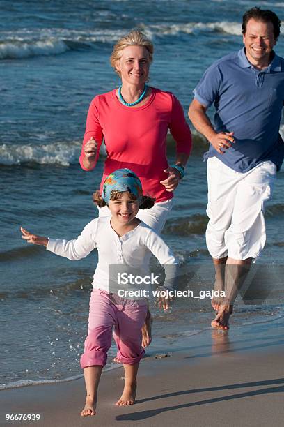 Família Jogando Na Praia - Fotografias de stock e mais imagens de Adulto - Adulto, Ao Ar Livre, Areia