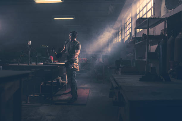 istock Full length of a worker hammering metal in a workshop. 966773922