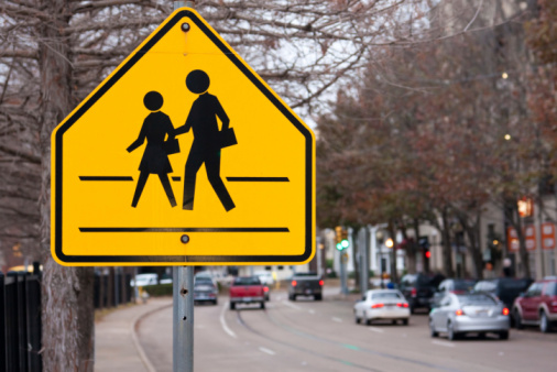 A road sign warning drivers to drive carefully and watch out for children crossing the road.