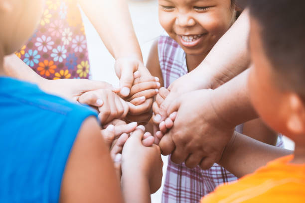 bambini e genitori che si tengono per mano e giocano insieme all'unità e al lavoro di squadra - figli foto e immagini stock