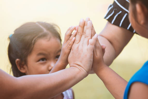 dzieci i rodzic trzymający się za ręce i bawiąc się jednością i pracą zespołową - praying protection life family zdjęcia i obrazy z banku zdjęć