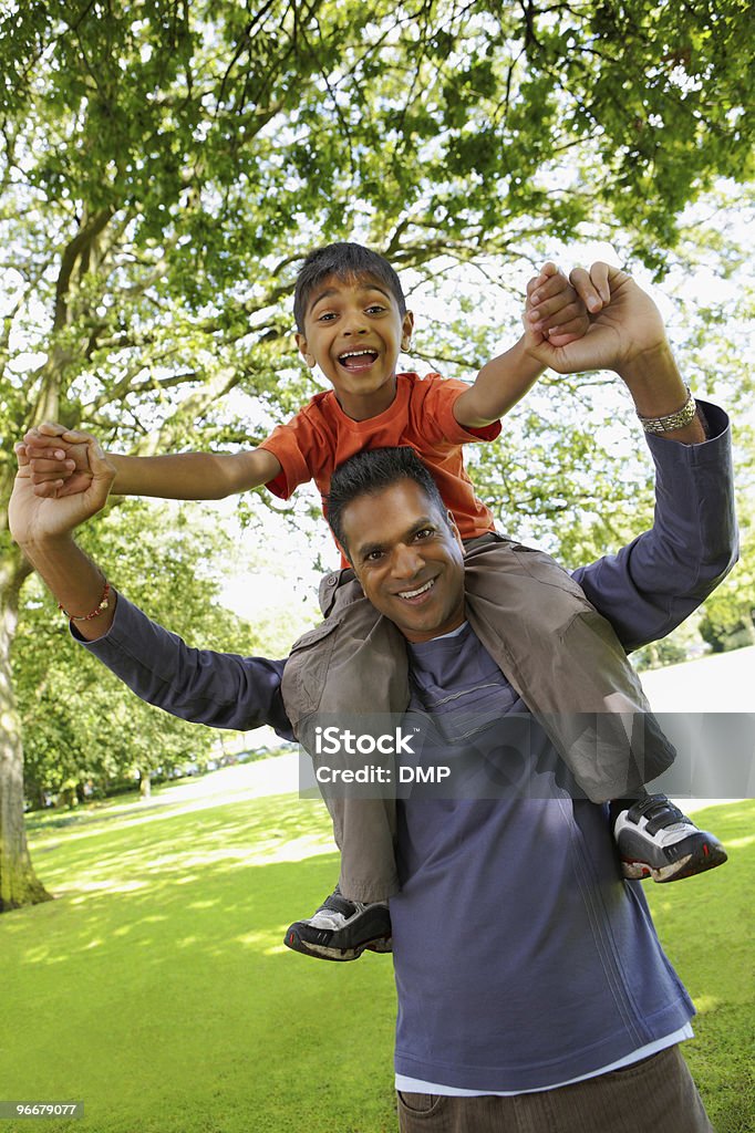 Jovem rapaz indiano dirigindo nos ombros de pais tendo diversão ao ar livre - Royalty-free 30-39 Anos Foto de stock