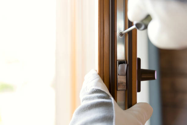 trabajador de la construcción en la casa de la ventana. la ventana de fijación con un destornillador de manitas - wooden doors fotografías e imágenes de stock