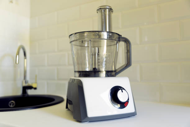 procesador de alimento eléctrico sobre la encimera de la cocina, fregadero de cocina en el fondo. fácil y rápida cocción, concepto de applience cocina - food processor fotografías e imágenes de stock