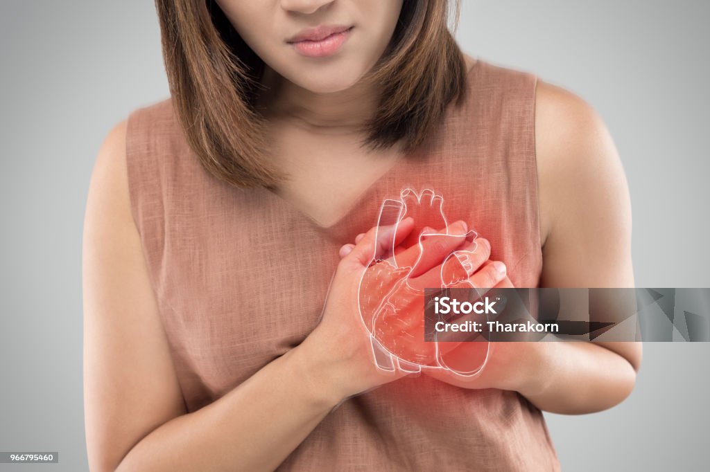 Heart attack The photo of heart is on the woman's body, Severe heartache, Having heart attack or Painful cramps, Heart disease, Pressing on chest with painful expression. Heart - Internal Organ Stock Photo