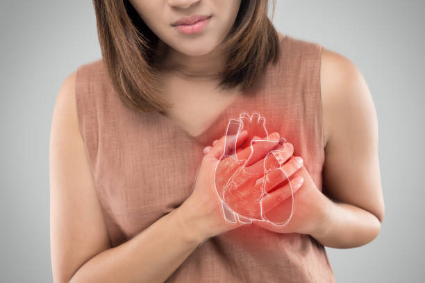 Heart attack The photo of heart is on the womans body, Severe heartache, Having heart attack or Painful cramps, Heart disease, Pressing on chest with painful expression. asian heart helth stock pictures, royalty-free photos & images