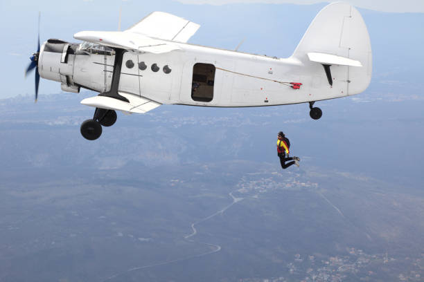 istock Parachutists jump from a vintage biplane 966808636