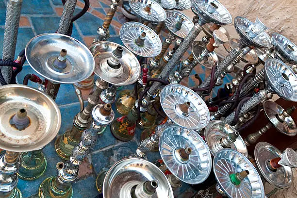 Arabic shisha, sometimes called hookah, waterpipes lined up on a the floor for customers in a restaurant in an Arabic country.