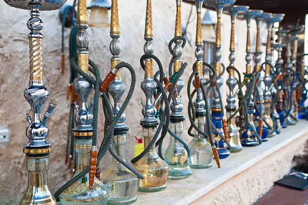 Arabic shisha, sometimes called hookah, waterpipes lined up on a bar for customers in a restaurant in an Arabic country.