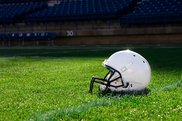 Single white football helmet on the field stock photo
