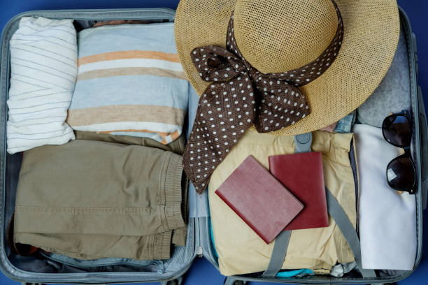 istock Open suitcase packed for travelling. Summer vacations. Top view 966831264