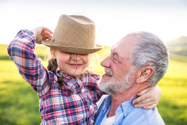 istock A small girl with grandfather outside in spring nature, having fun. 966836618