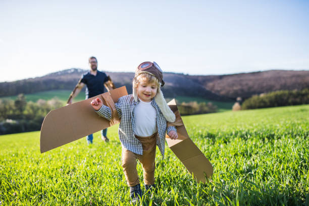 istock Happy toddler boy playing outside with father in spring nature. 966840896