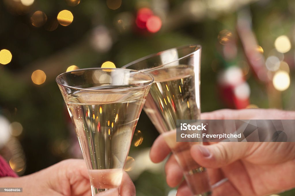 Mann und Frau mit Champagner Anstoßen in Front of Lights - Lizenzfrei Alkoholisches Getränk Stock-Foto