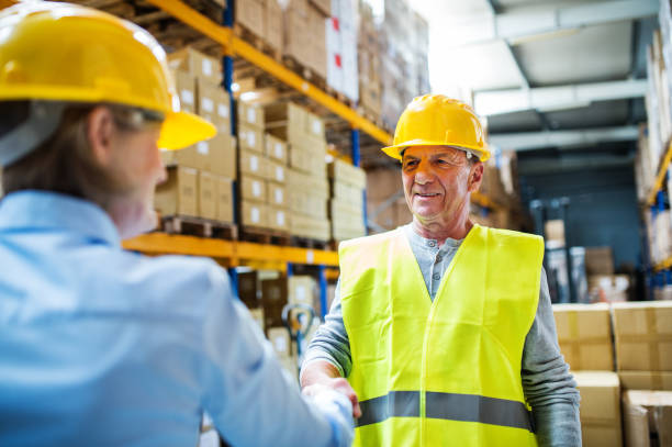 istock Senior woman manager and man worker working in a warehouse. 966855644