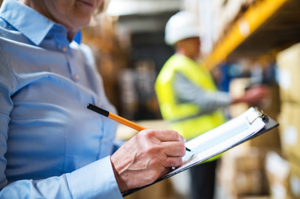 istock Senior woman manager and man worker working in a warehouse. 966855906