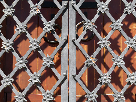 Vintage lattice and wooden gates on facade of ancient building