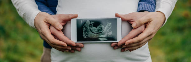 mężczyzna pokazujący usg nad brzuchem swojej żony - human pregnancy telephone ultrasound family zdjęcia i obrazy z banku zdjęć