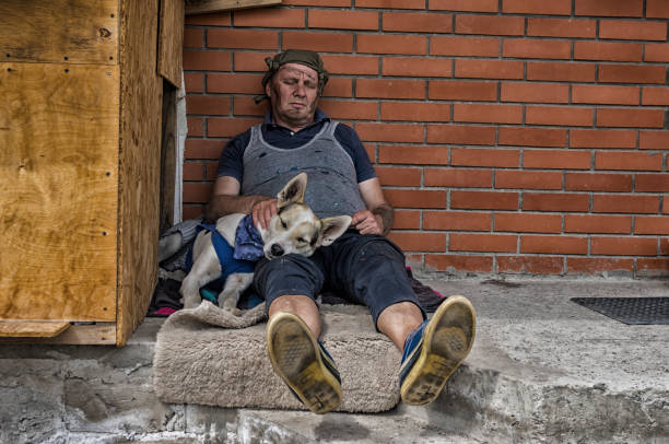 Hombre y perro durmiendo sentado en una contra pared de ladrillos de hormigón - foto de stock