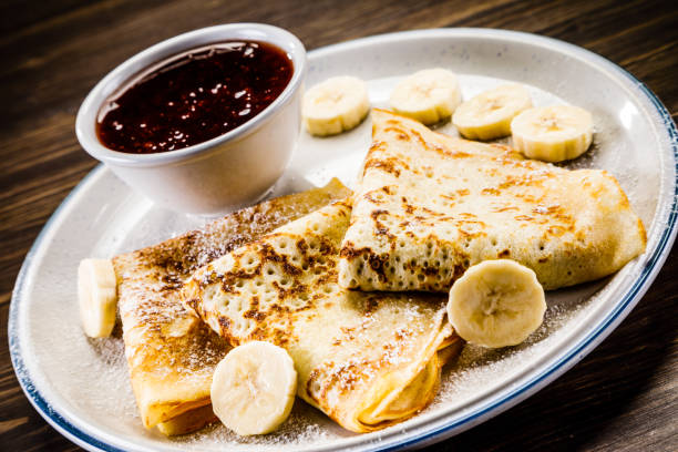 istock Crepes with banana, cream and fruit syrup 966864738