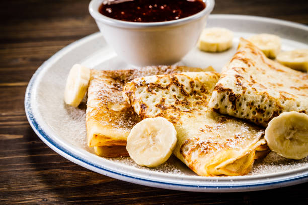 istock Crepes with banana, cream and fruit syrup 966864852