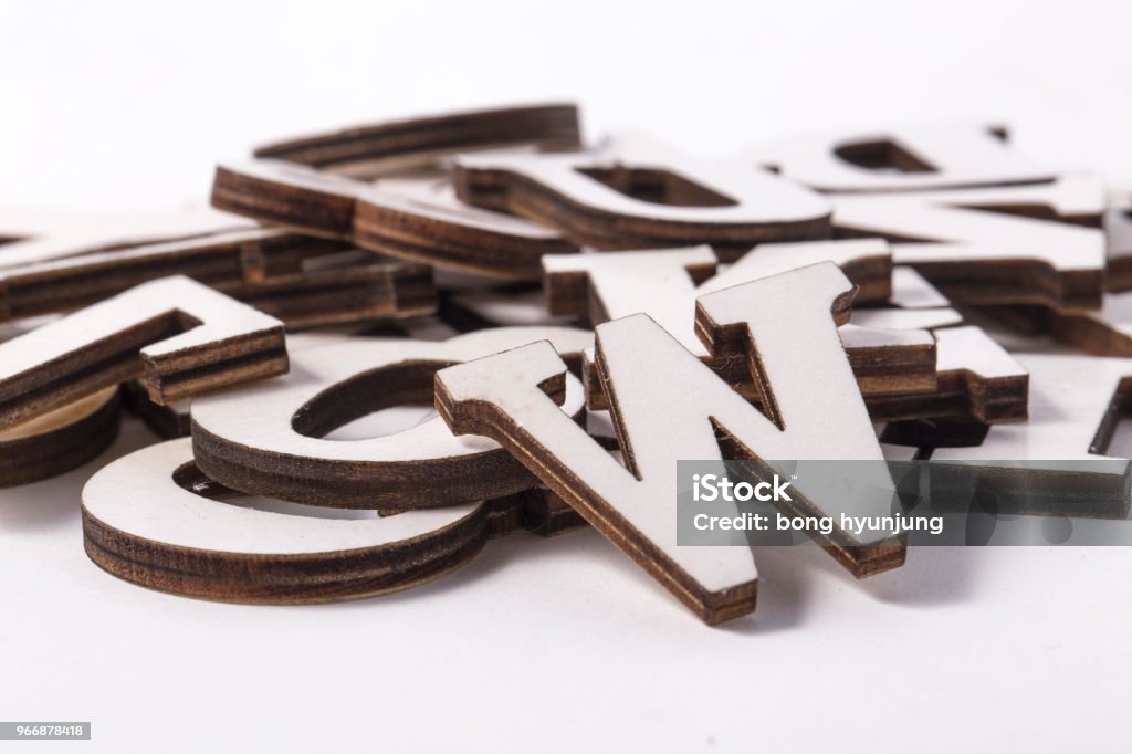 Alphabet letters on wooden scrabble pieces, isolated on white. Text Stock Photo