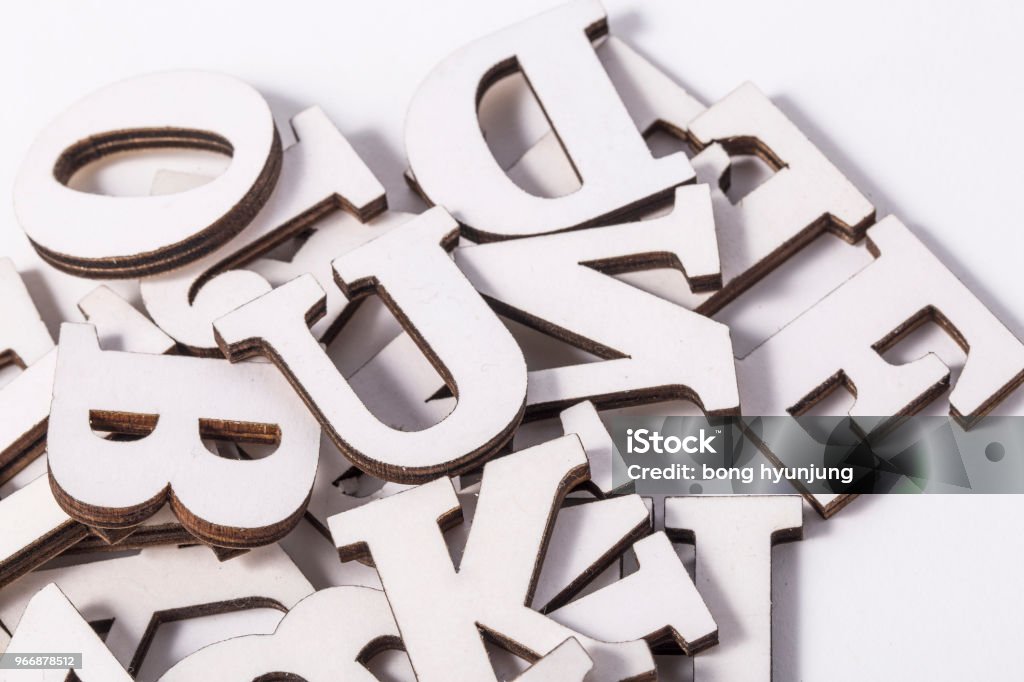 Alphabet letters on wooden scrabble pieces, isolated on white. Activity Stock Photo