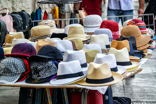 Photo of street commerce, with many hats.