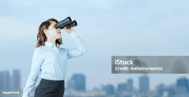 Young Businesswoman Using Binoculars In Front Of The City Stock Photo - Download Image Now