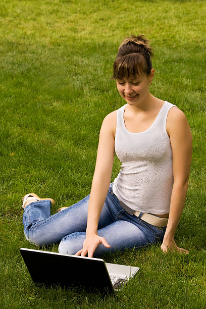 istock Young woman with notebook on the grass 96690175