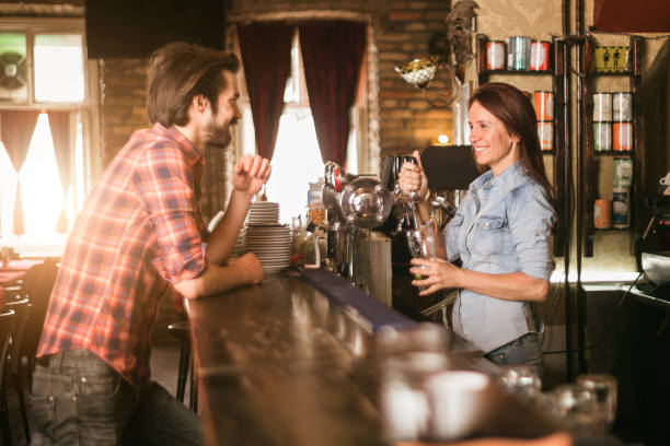 istock Female bartender serving beer to a costumer 966909530