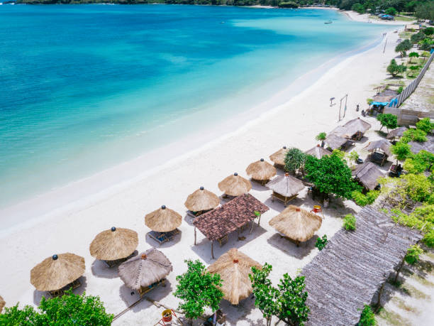 istock Straw beach umbrellas and blue ocean. Beach scene from above 966910566