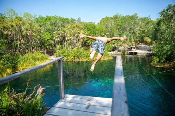 Man diving in Beautiful Cenote in Riviera Maya in Mexico, Yucatan Cenote Cristalino