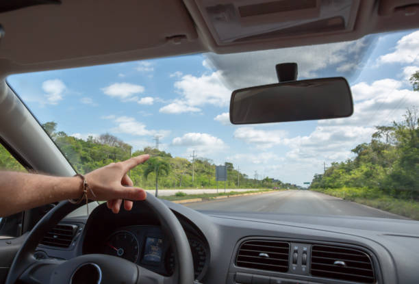 istock Man driving car on mexican highway, car inside view 966911144