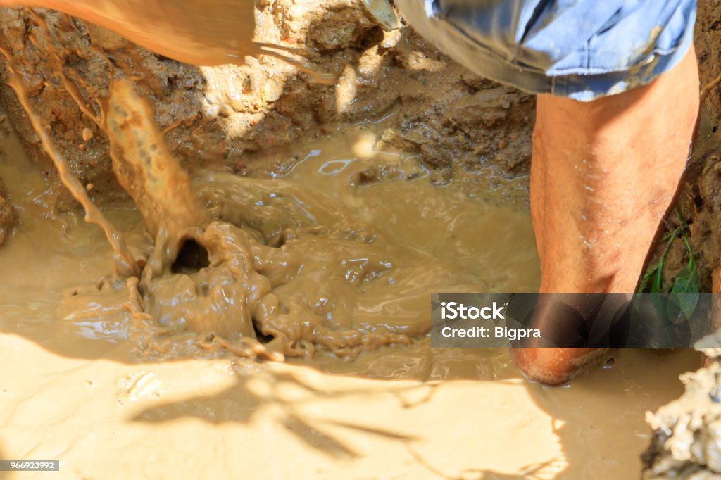 male plumber are repair broken pipe in hole with plumbing water flow outdoor and sunlight with copy space add text Adult Stock Photo