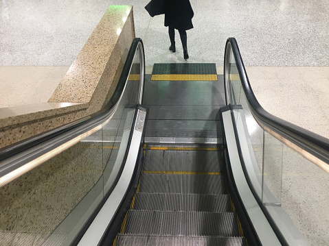 Unrecognisable woman exiting the escalator