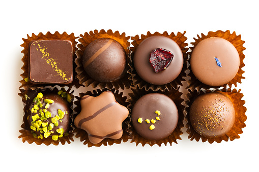 Various chocolate pralines isolated on white background. Top view.